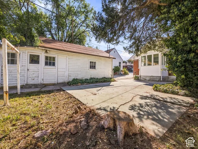Detached structure with wood lap siding, asphalt shingle roof, and concrete hardscaping