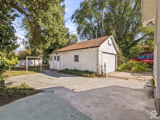 Detached garage with a gable roof, white horizontal siding, and a concrete driveway