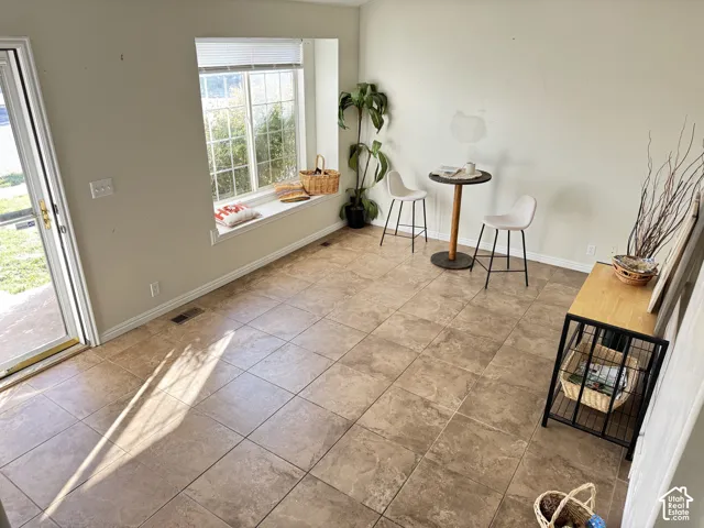 Large-format tile flooring, built-in window seat, and glass-paneled exterior door