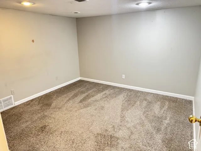 Neutral-toned interior space featuring wall-to-wall carpeting and recessed ceiling lighting