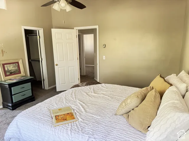 Vaulted ceilings, neutral wall tones, wall-to-wall carpeting, ceiling fan with light kit, and traditional panel doors