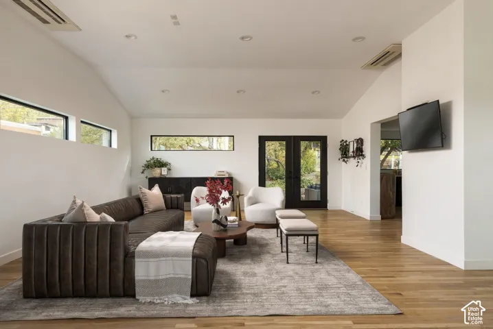 Vaulted ceilings, wood-finish flooring, recessed lighting, clerestory windows, and double glass-panel doors