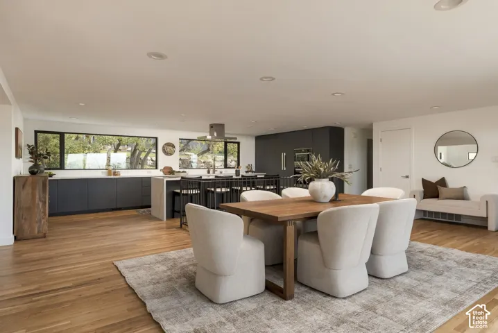 Modern kitchen featuring flat-panel cabinetry, a central island with stone-finish countertops, recessed ceiling lighting, and wood-finish flooring