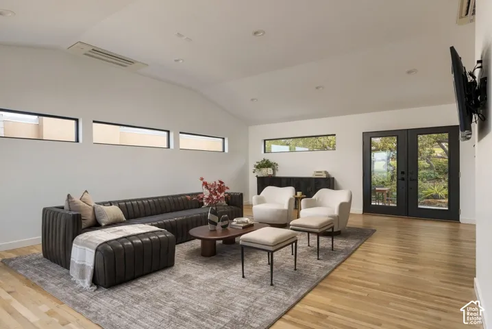 Vaulted ceilings with recessed lighting, horizontal clerestory windows, wood-finish flooring, and black-framed double doors