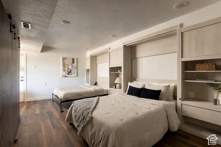 Custom light-tone built-in cabinetry featuring integrated shelving, wood-finish flooring, and a sliding barn-style door