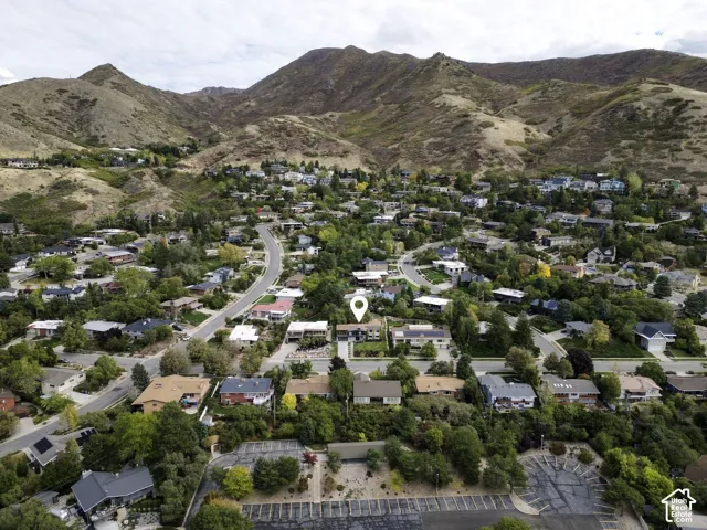 Aerial perspective of residential property featuring a mountain backdrop and mature tree canopy