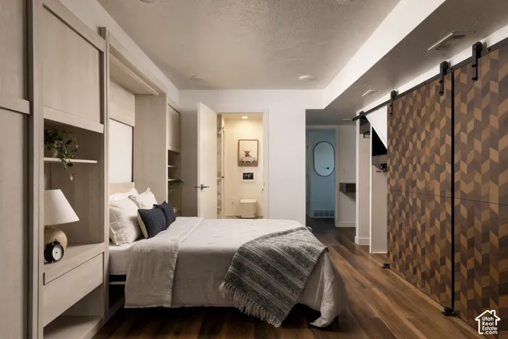 Built-in floor-to-ceiling light wood cabinetry, wood-finish flooring, and dual sliding barn doors featuring a geometric wood inlay pattern