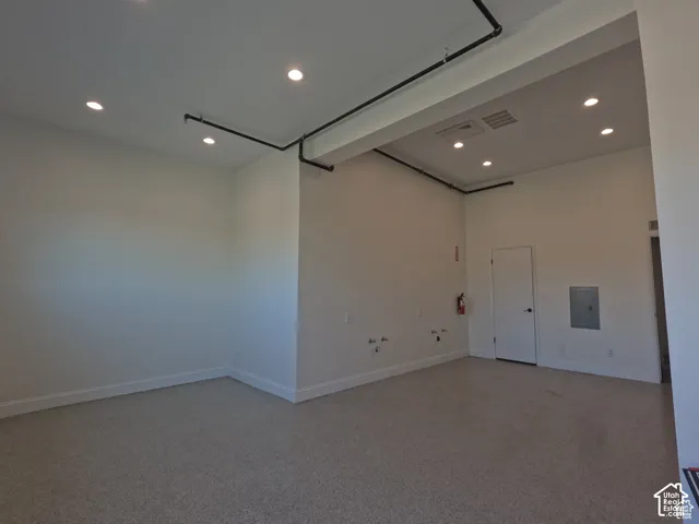128 E, Commercial space. 493 SF. Open space featuring high ceilings, recessed lighting, exposed industrial-style piping, and coated concrete flooring