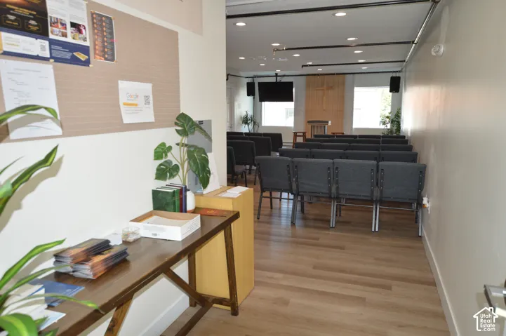 Open-concept interior space featuring wood-finish flooring, recessed lighting, and large windows with natural light