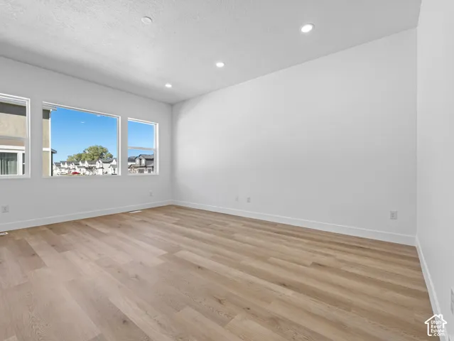 Interior space featuring wood-finish flooring, recessed lighting, and multiple large windows