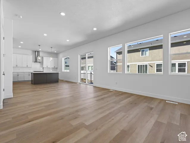 Open-concept interior featuring wood-finish flooring, recessed lighting, and large picture windows