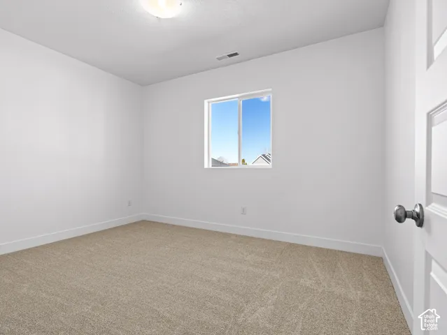 Neutral wall color, wall-to-wall carpeting, and a sliding window featuring a matte silver finish door handle