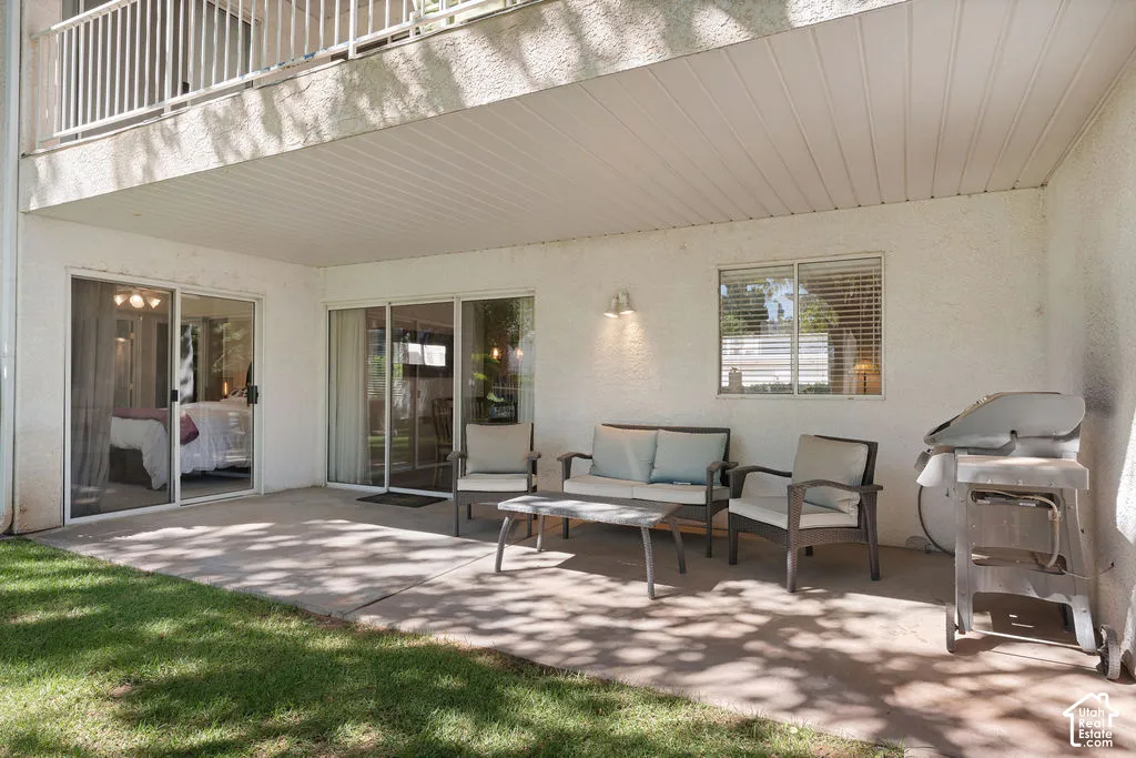 Covered patio with concrete flooring, two sliding glass doors, and a double-hung window