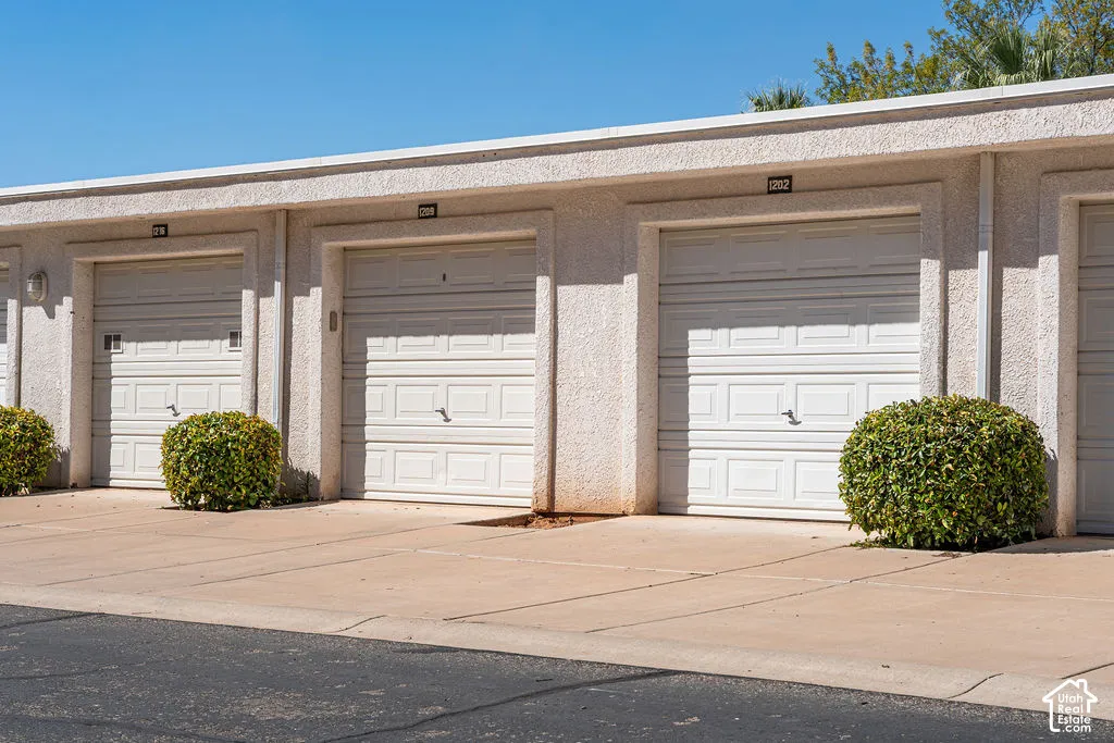 Individual garage entries with white panel doors and exterior lighting
