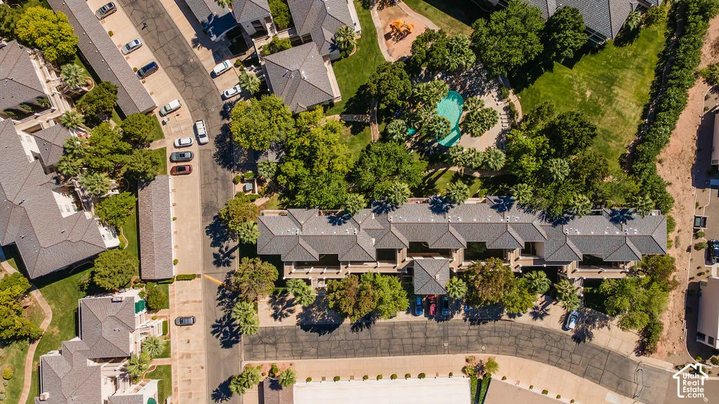 Residential complex featuring multiple buildings with dark-toned roofs, mature landscaping, and an outdoor swimming pool