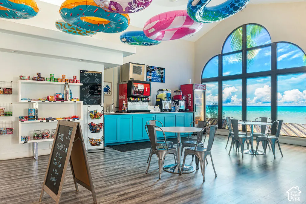 Expansive arched window with water scenery, durable wood-finish flooring, and built-in teal cabinetry