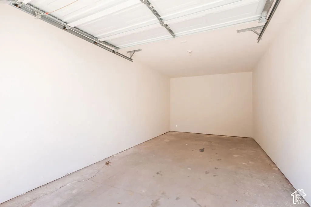 Garage with a concrete floor, painted walls, and an overhead door mechanism