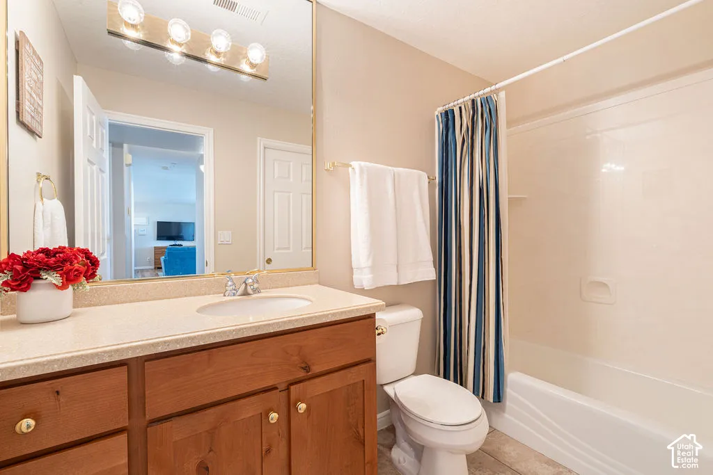 Bathroom with a wood-finish vanity, light-colored countertop, and integrated sink