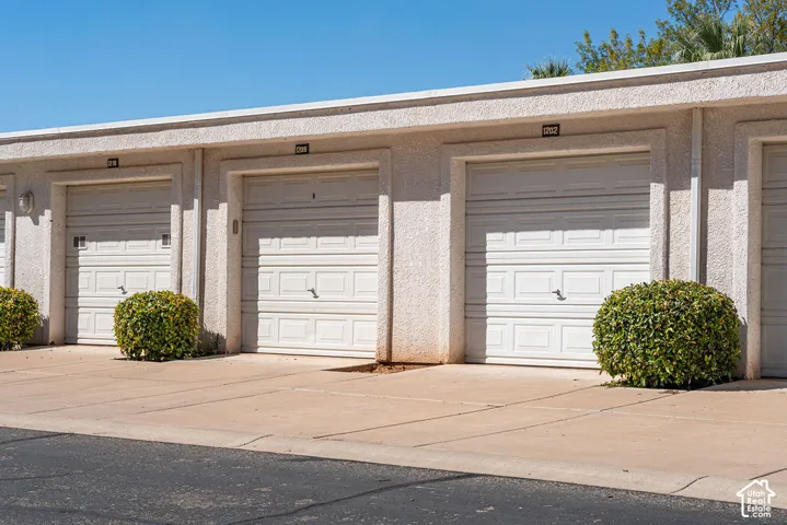 Individual garage entries with white panel doors and exterior lighting