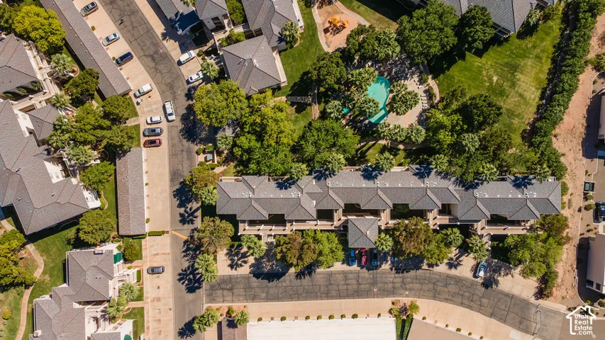 Residential complex featuring multiple buildings with dark-toned roofs, mature landscaping, and an outdoor swimming pool
