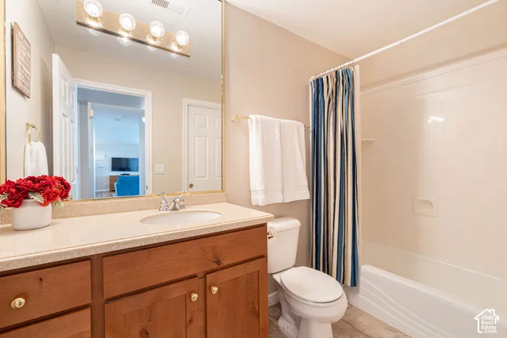 Bathroom with a wood-finish vanity, light-colored countertop, and integrated sink