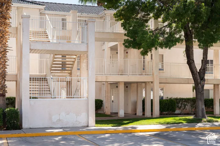 Multi-level stucco exterior with white railings and exterior staircases