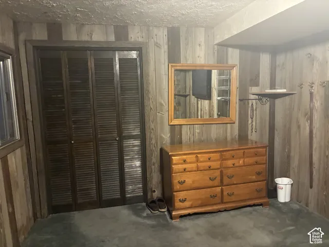 Vertical wood paneling featuring a floor-to-ceiling application and a built-in closet with four-panel louvered doors