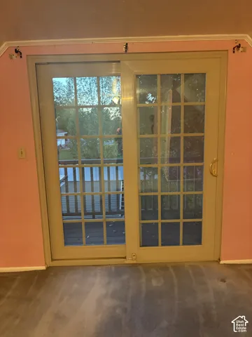 Sliding glass door with a multi-pane grid design, metallic hardware, and neutral-toned framing