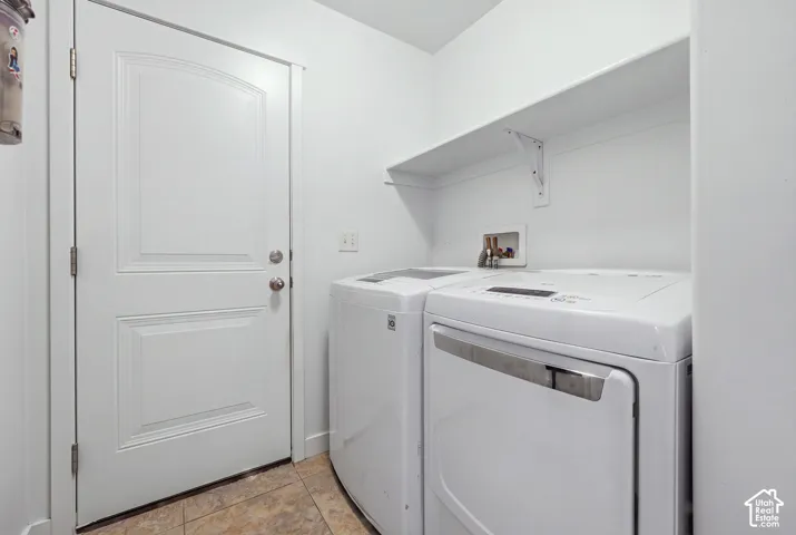 Laundry area featuring tile flooring, a solid-core door, and overhead shelving