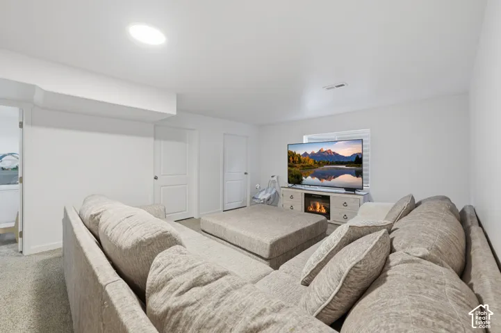 Neutral-toned carpeted flooring, white interior walls, two interior doors, and a recessed ceiling light fixture