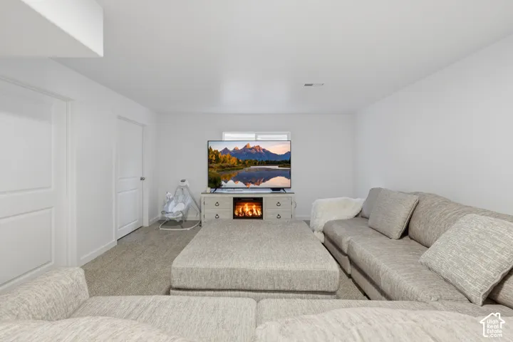 Neutral-toned room featuring wall-to-wall carpeting, crisp white walls, and a recessed ceiling light