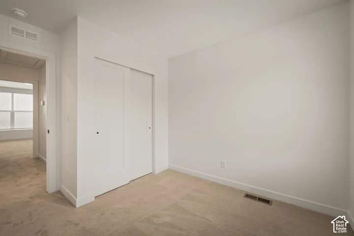 Neutral interior with wall-to-wall carpeting and sliding double-panel closet doors