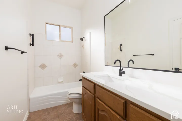 Bathroom featuring a wood-finish vanity with a stone countertop, an integrated rectangular sink, matte black plumbing fixtures, and a large wall-mounted mirror