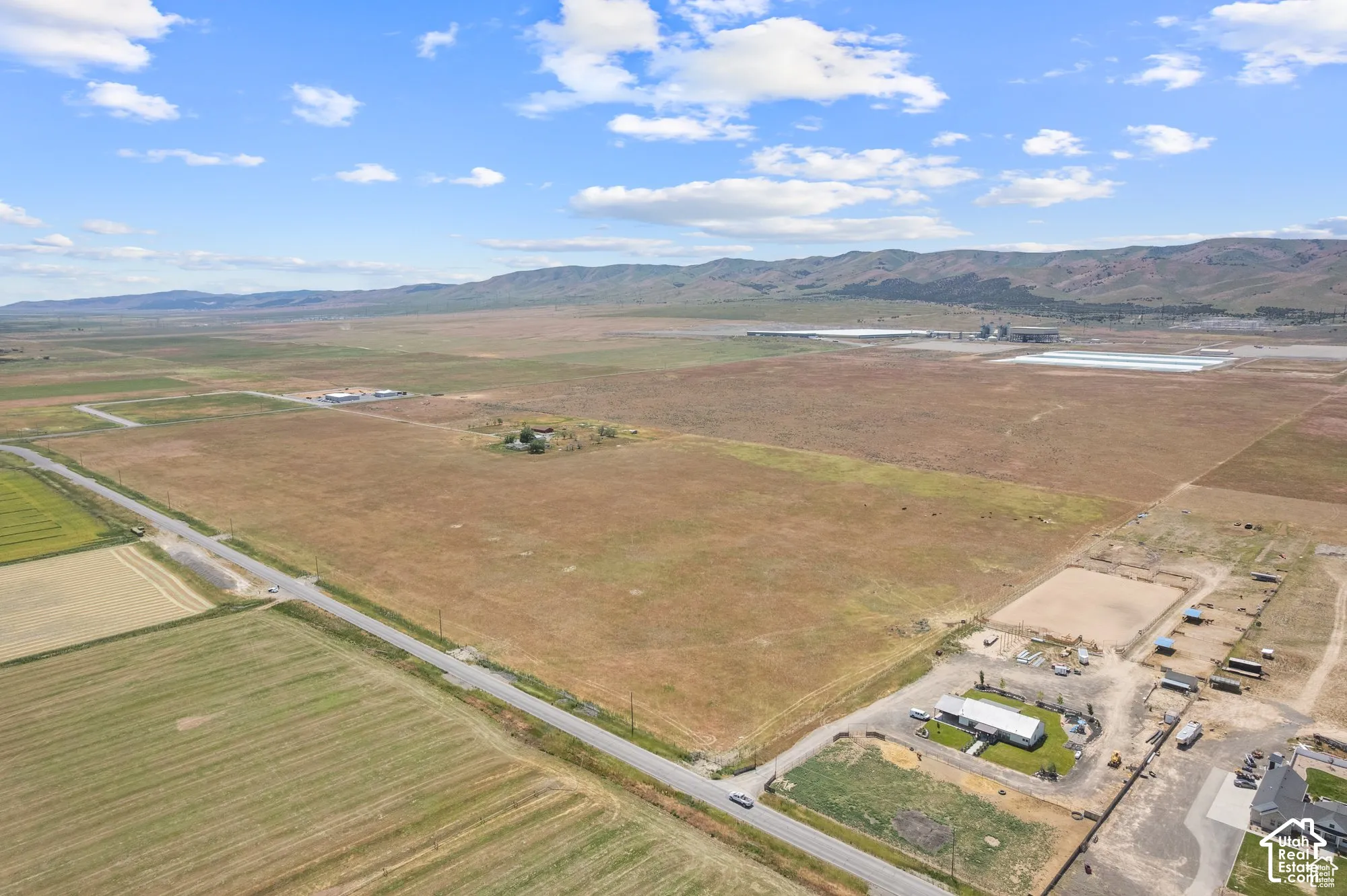 Expansive acreage featuring open terrain, mountain backdrop, and direct paved road frontage