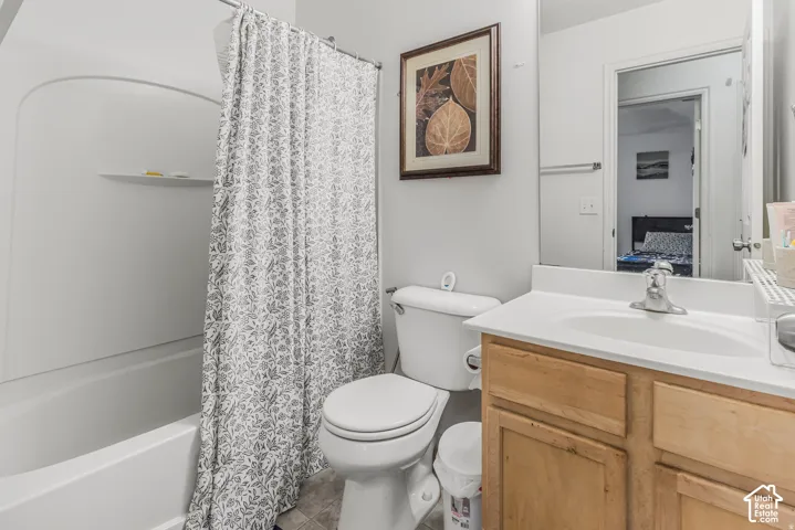 Bathroom featuring a wood-finish vanity with a white countertop, integrated sink, large wall mirror, and a tub-shower combination with a molded surround