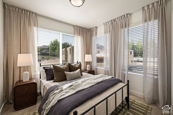 Room featuring dual-aspect windows, horizontal blinds, wall-to-wall carpeting, and a central ceiling-mounted light fixture