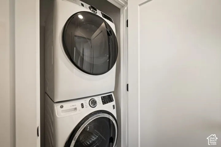 Stackable white front-load washer and dryer units housed within a dedicated closet