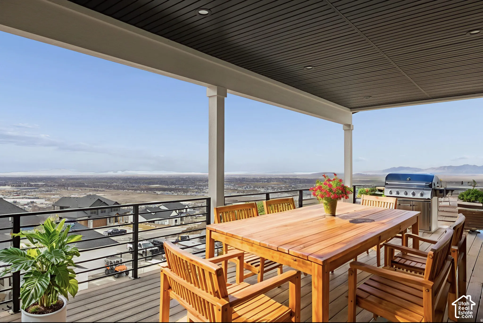 Covered balcony featuring composite decking, black metal railing, recessed ceiling lighting, and a panoramic mountain and valley backdrop