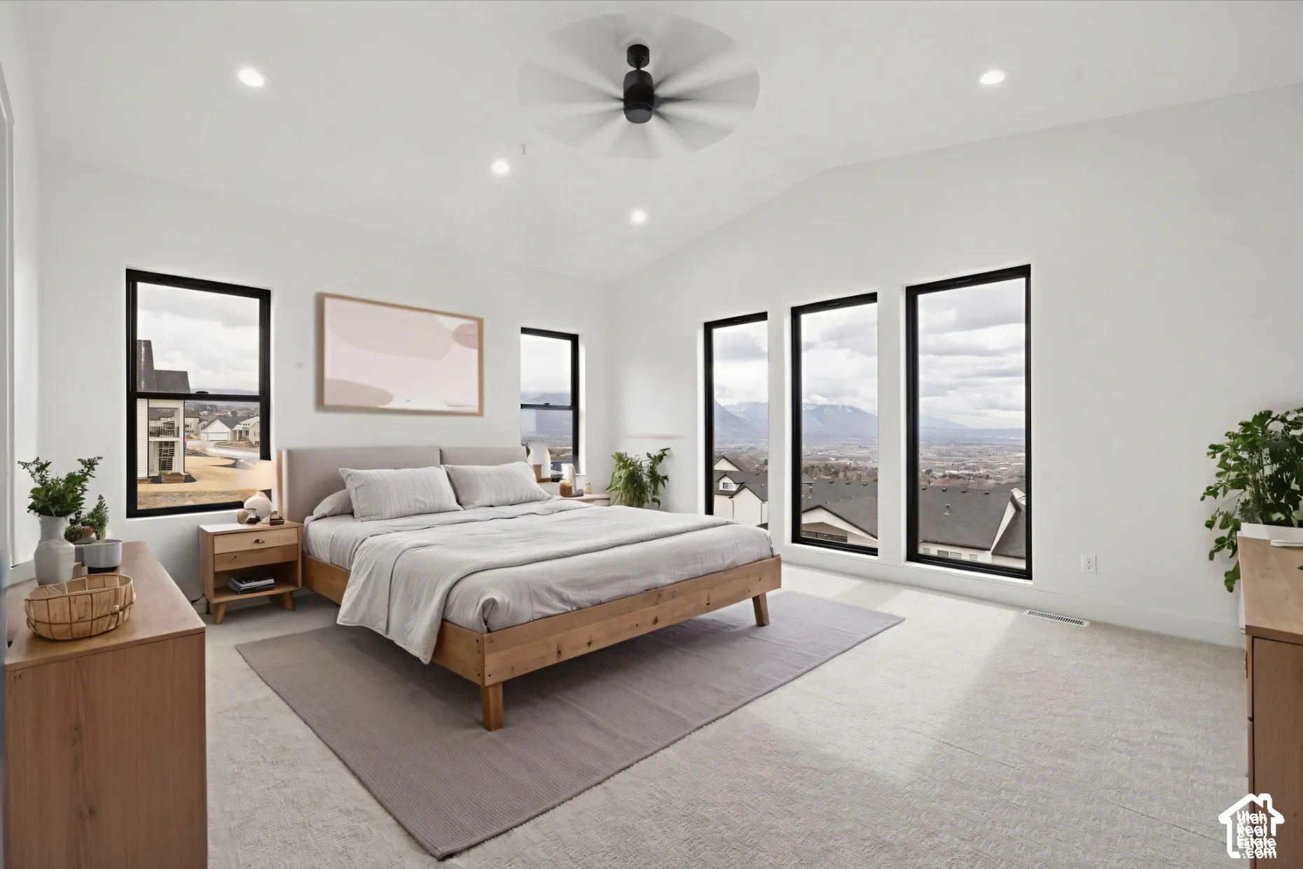Vaulted ceilings, expansive windows with black frames, recessed lighting, and a centralized ceiling fan