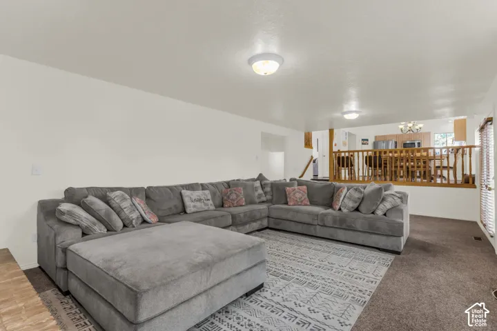 Living area featuring neutral wall paint, recessed ceiling lighting, and a wood-slat railing