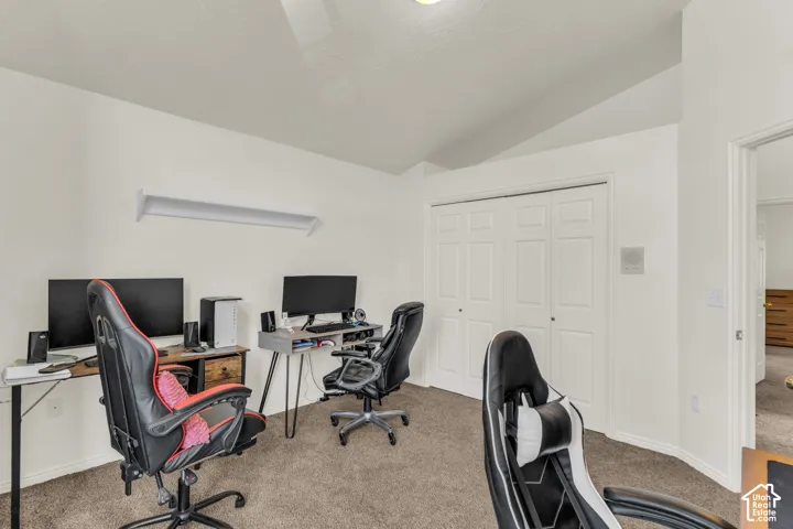Vaulted ceilings, carpeted flooring, and a closet with bifold doors