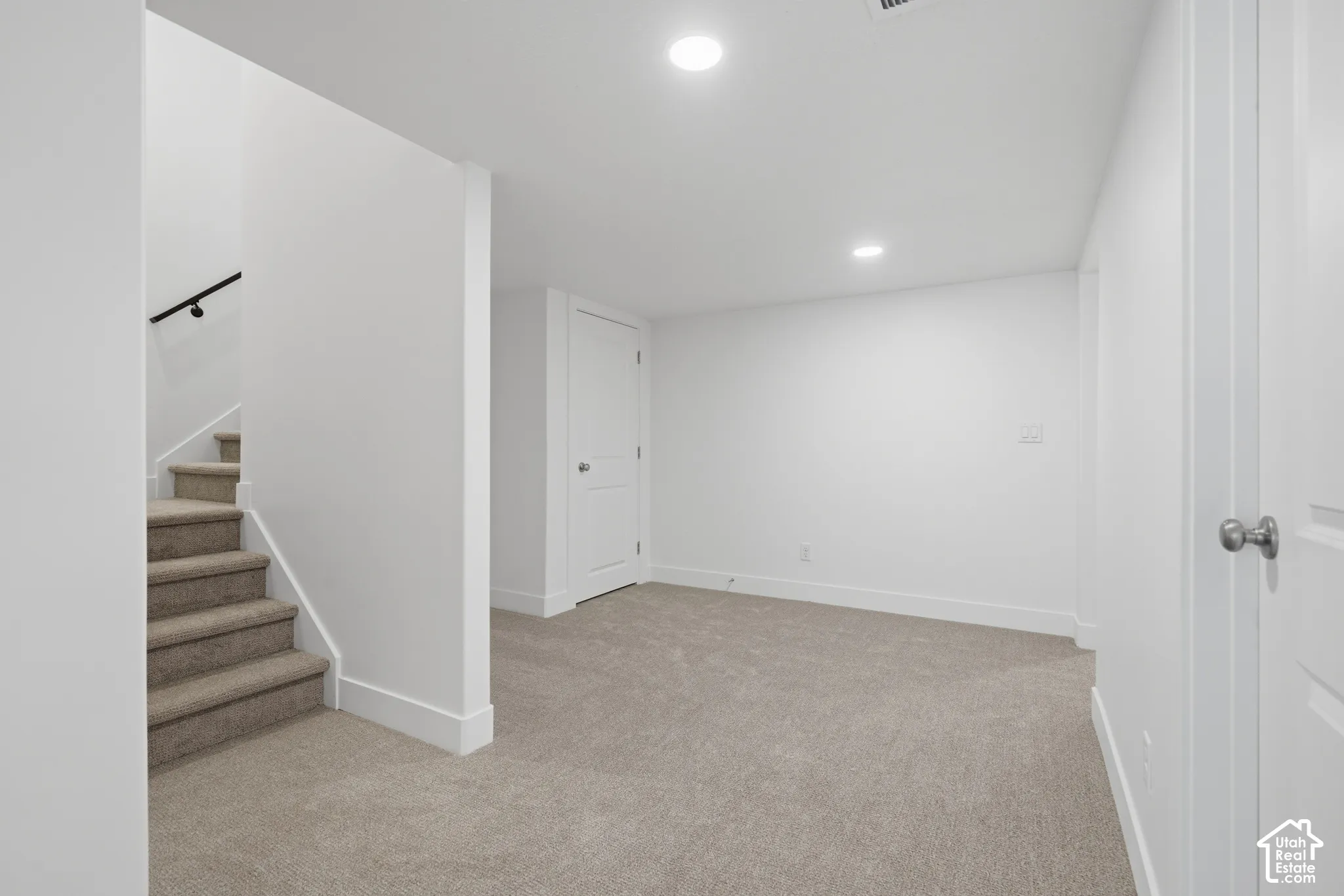 Neutral-toned carpeting, recessed ceiling lighting, and solid-core interior doors