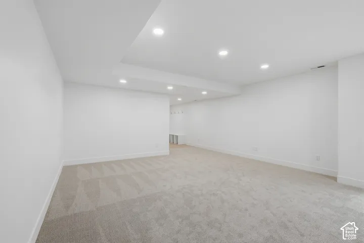 Neutral interior featuring a dropped tray ceiling, recessed lighting, wall-to-wall carpeting, and built-in storage bench with wall-mounted hooks