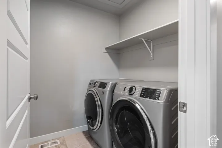 Dedicated laundry area featuring tile flooring and built-in upper shelving
