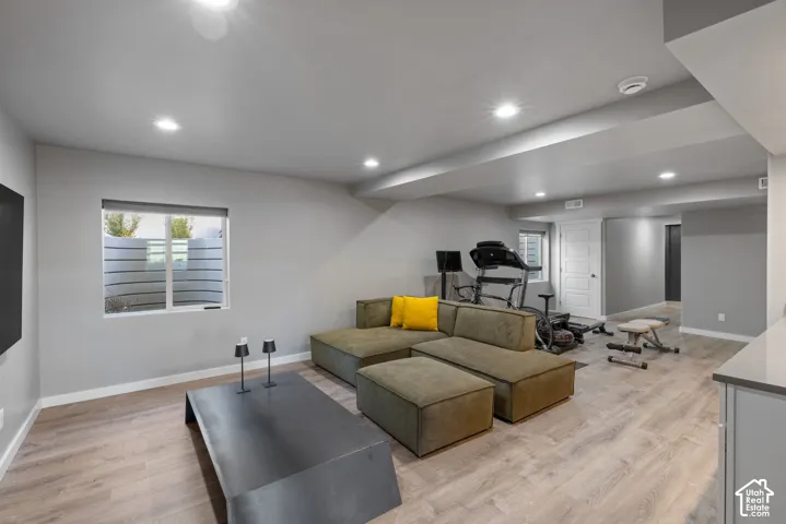 Spacious room featuring wood-finish flooring, recessed lighting, and a window egress well