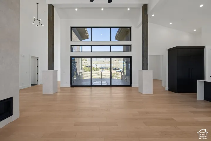 Vaulted ceilings, large-format multi-pane windows, wood-finish flooring, floor-to-ceiling structural pillars, and recessed lighting