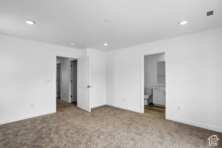 Neutral-toned wall-to-wall carpeting, recessed ceiling lighting, and solid-core interior doors