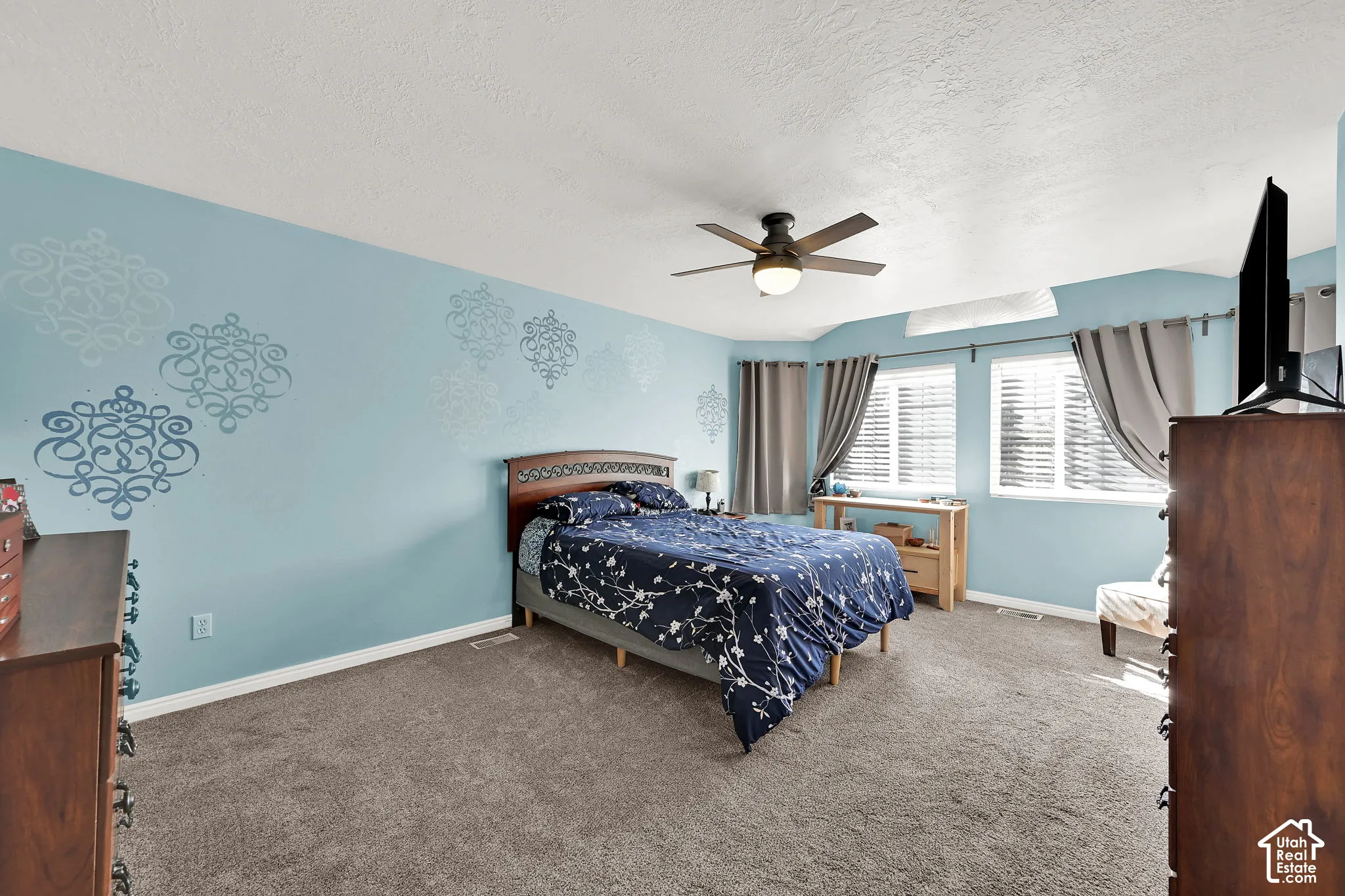 Room featuring wall-to-wall carpeting, dual windows, and a ceiling-mounted light fixture with fan