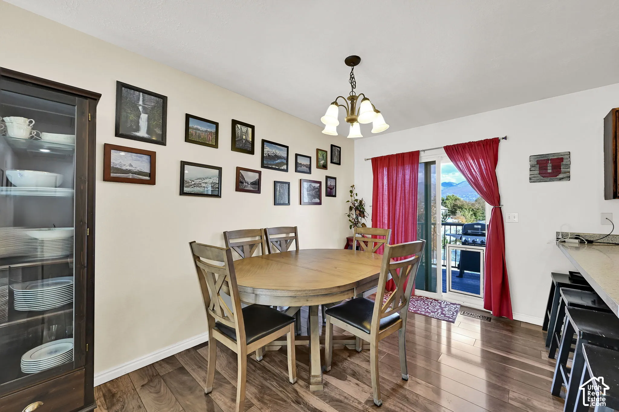 Dining area featuring wood-finish flooring, a multi-arm chandelier, built-in cabinetry, and sliding glass doors