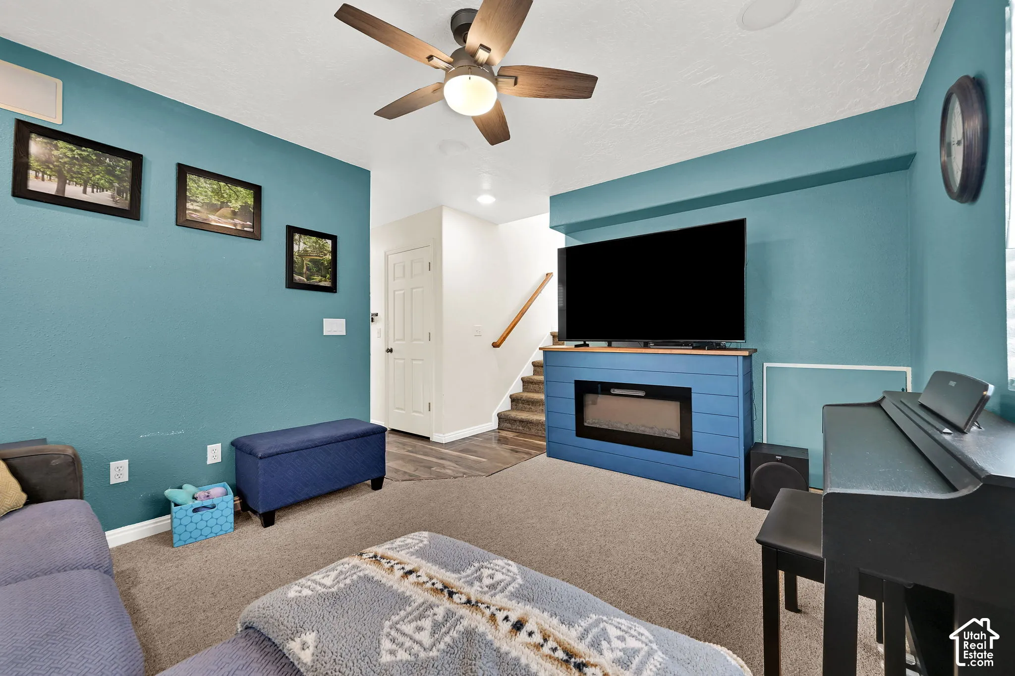 Living area featuring a built-in electric fireplace with a horizontal plank surround, wall-to-wall carpeting, recessed lighting, and a ceiling fan with integrated light